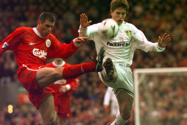 Liverpool's Jamie Carragher clears the ball under pressure from Harry Kewell.