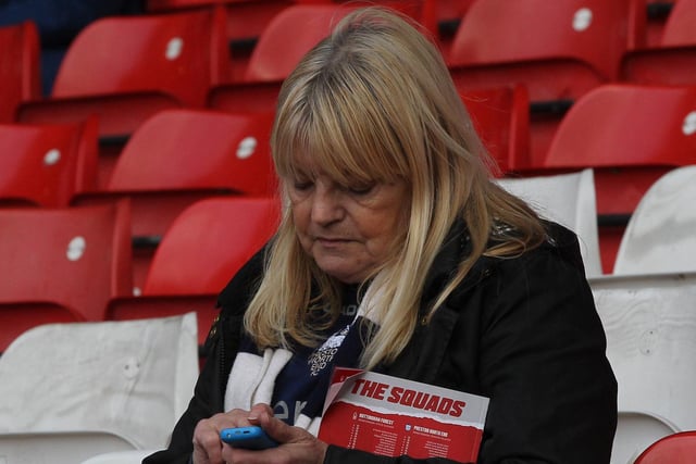 This PNE fan has her phone and match day programme to keep her attention before the Forest game