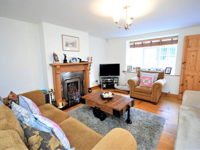 A fireplace is a central focal point in this good size lounge within the cottage.