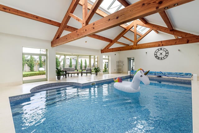 The impressive indoor swimming pool with a resistance water jet, separate changing room and glazed bay seating area.