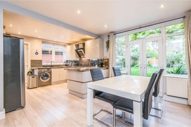 The kitchen dining room is modern, with fitted appliances and space for a family dining table. Double doors lead out into the garden.