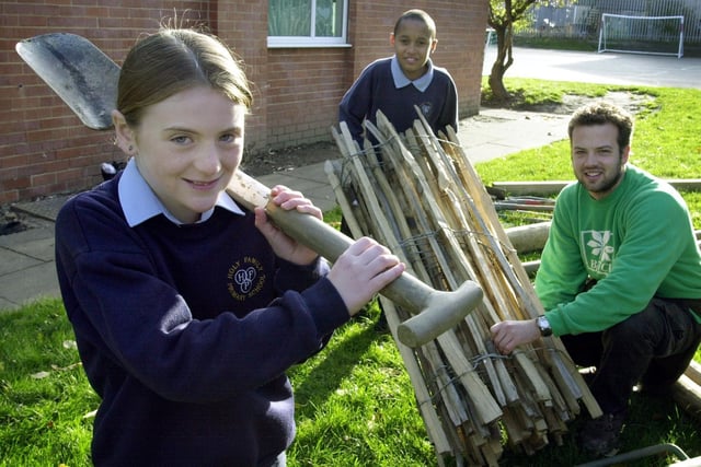 Holy Family RC Primary pupils Tara Wyles and Clark Thomas-Barr help Stuart Harris from the BTCV Holybush Centre in Kirkstall put up fencing at the school in November 2001.