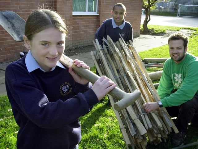 Holy Family RC Primary pupils Tara Wyles and Clark Thomas-Barr help Stuart Harris from the BTCV Holybush Centre in Kirkstall put up fencing at the school in November 2001.