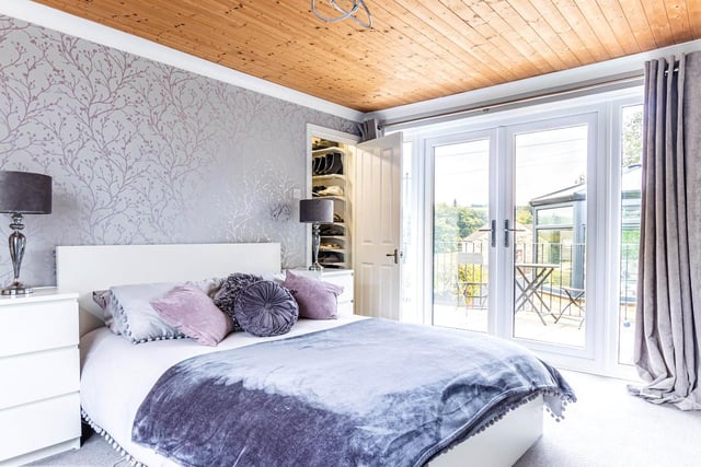 A luxurious bedroom with access to a raised decked seating area.