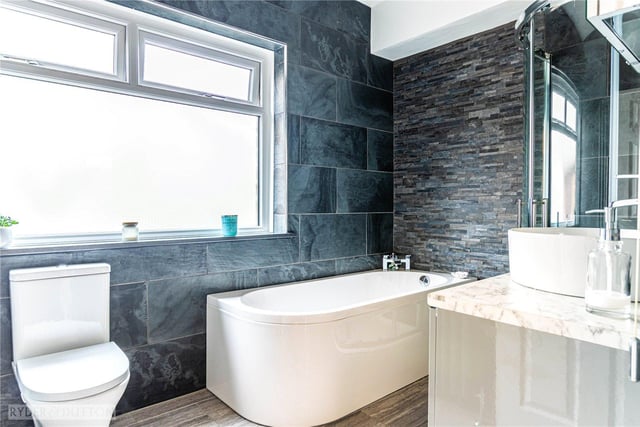 This stunning bathroom includes a deep bath, a shower and a built-in vanity unit.
