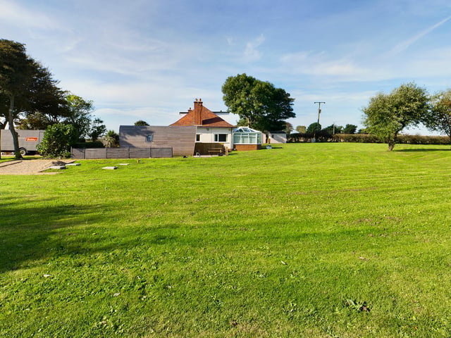 An expanse of lawn with established trees around the property.