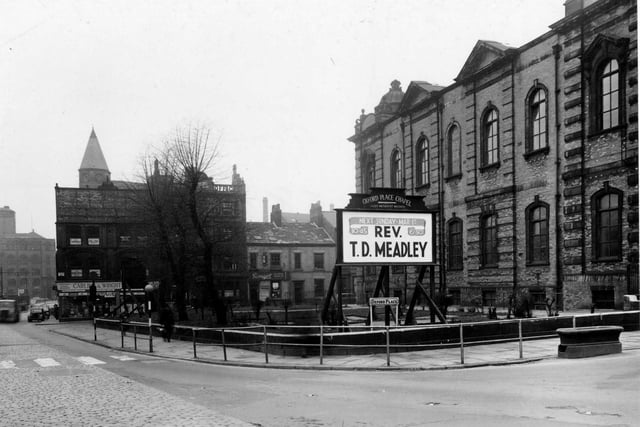 Oxford Place Chapel (Leeds Methodist Mission), on the junction of Park Lane and Oxford Place in February 1953. In the foreground is the chapel's notice board, advertising that the Rev. T.D. Meadley will take services on March 1. Behind, Carling & Wright (Leeds) Ltd, electrical repairs, can be seen. Also visible is Savages of Leeds Ltd., motor spares.