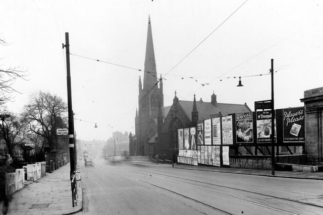 Woodhouse Lane in February 1953. On the right are advertising hoardings, with "for sale" sign over, and Trinity Congregational Church. Pictured left is Blenheim Terrace.