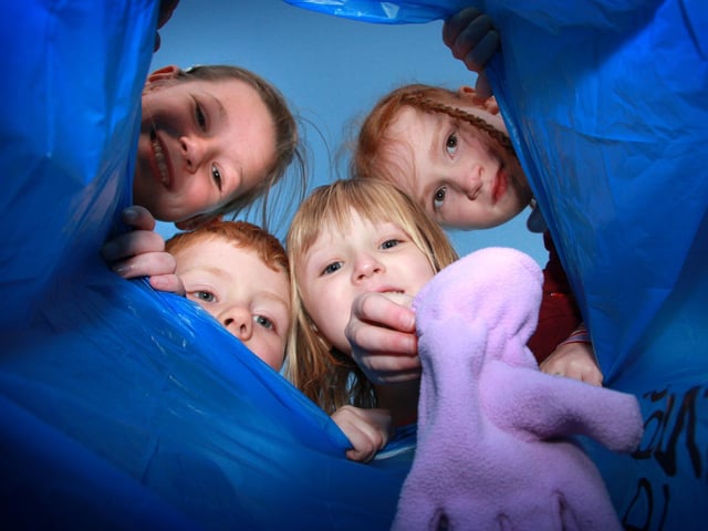 Glaisdale School pupils place clothes in a bag ready for a charity collection.