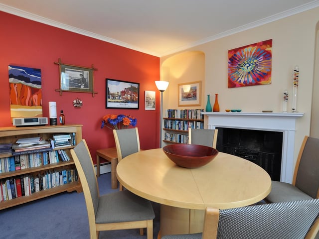 A pleasant dining room with a feature fireplace and alcove detail to the wall.