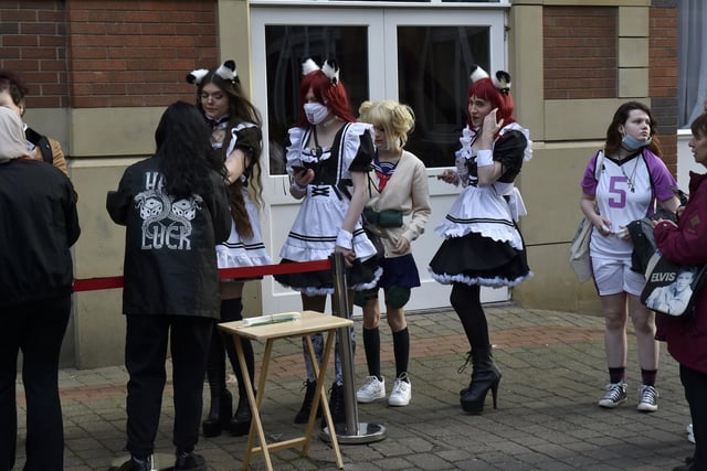 People sport their best cosplay outfits as they queue to enter the convention on Saturday