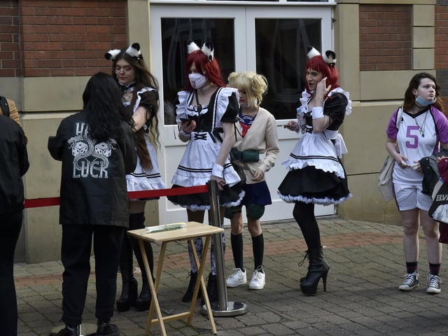People sport their best cosplay outfits as they queue to enter the convention on Saturday