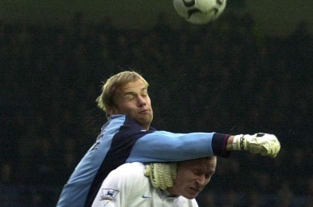 Bolton goalkeeper Jussi Jaaskelainen punches clear under pressure from Seth Johnson.
