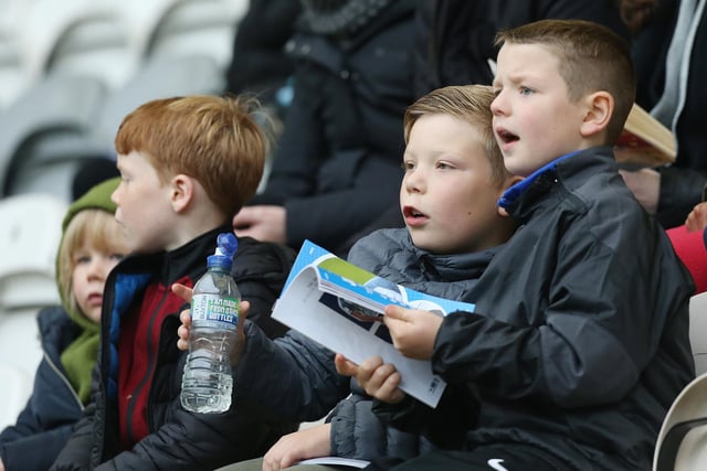 Something takes the attention of these young PNE supporters away from a drink and the match day programme
