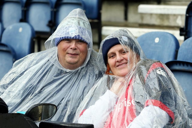 These PNE fans attempt to keep the rain off at Deepdale