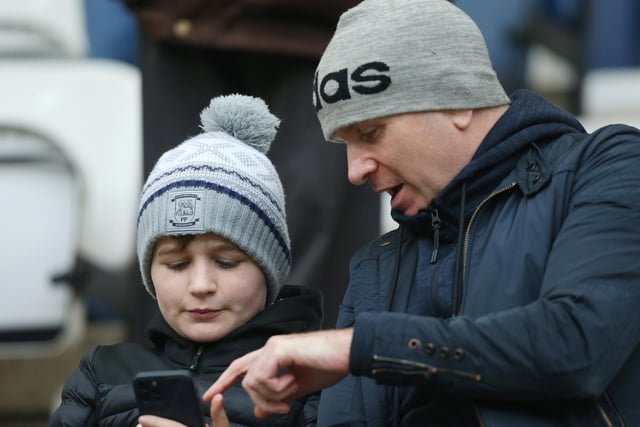 Two PNE fans check their phone before the Cardiff game
