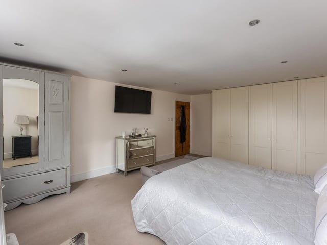 Space features in this large double bedroom with fitted furniture.