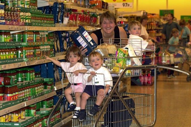 Rebecca Holley pictured shopping in Durkar's Asda store with her triplets after the supermarket giant made her a special trolley. Pictured is Sam (back) with Charlotte and Joe, all aged 18 months in July 2000.