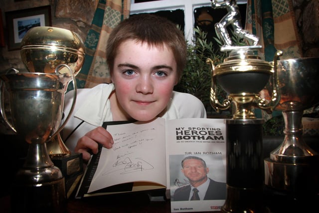 Liam Featherstone with his cricket trophies and a signed picture of Ian Botham.