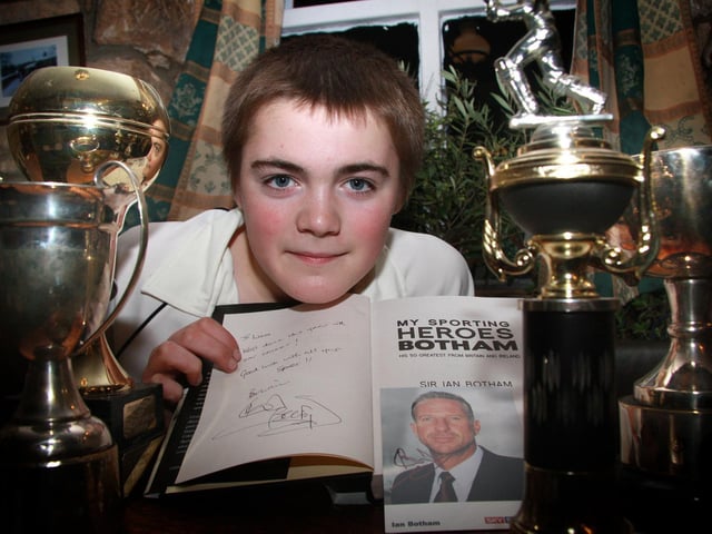 Liam Featherstone with his cricket trophies and a signed picture of Ian Botham.