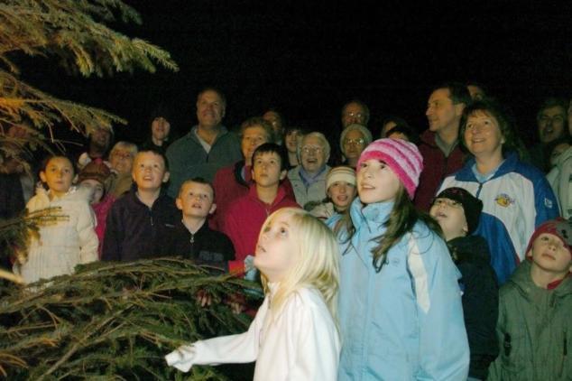 Villagers singing carols at the Kirkhamgate Christmas tree in the centre of the village