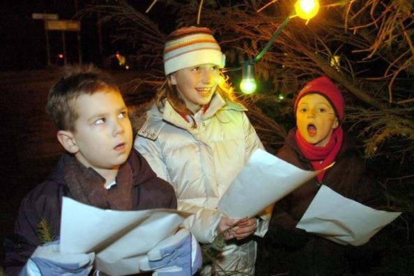Joe, Rosie and Max singing carols at the Kirkhamgate Christmas tree in the centre of the village near Wakefield