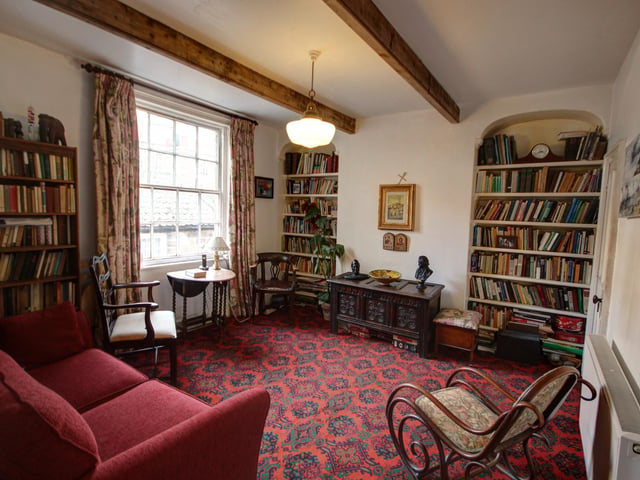 This sitting room has alcove features, that are currently lined with bookshelves.