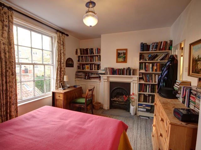 This bedroom has a charming fireplace as a focal point,