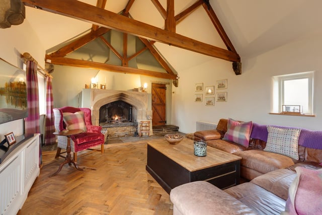 A stunning feature fireplace and vaulted ceiling bring great warmth and character to this room within Sycamore Farm, Derbyshire.