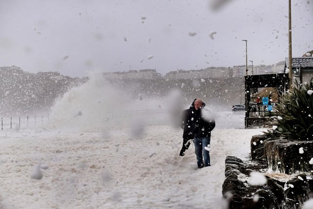 Waves and foam crash into the sea wall on Royal Albert Drive in the North Bay.