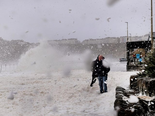 Waves and foam crash into the sea wall on Royal Albert Drive in the North Bay.