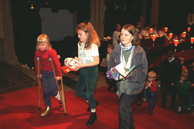 Children make their way forward to place gifts under the Christmas tree at the Yorkshire Evening Post Carol Service held at Leeds Parish Church.