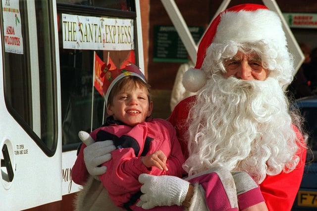 Victoria Chesworth, one of the children from Milestone Special School, gets a lift from Santa outside ASDA at the Owlcotes Centre in Pudsey.
