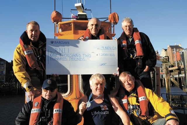 Runner Dennis Booth presents a cheque to the Whitby lifeboat crew.