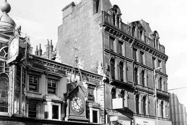 Briggate in January 1978. On the left is John Dyson & Sons, Jewellers and Watchmakers, which has two ornate clocks, one displaying the year 1865 in which the business was founded. Next to this is Jet Dry Cleaners, then Boar Lane Discount Warehouse, on the corner with Boar Lane which can just be seen on the right of the picture.