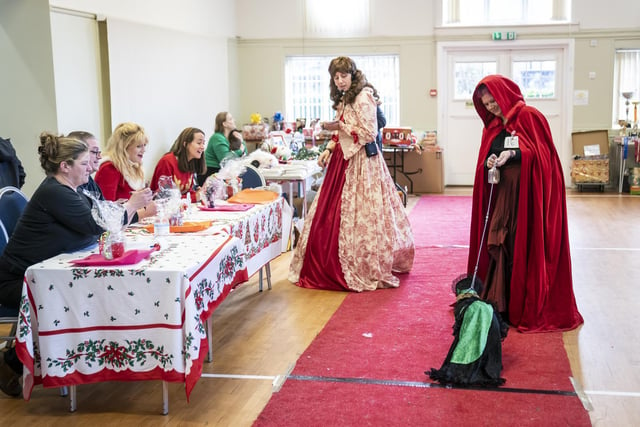 Judges (left) watch on as a woman walks her dog down the catwalk during the Victorian Christmas themed Furbabies Dog Pageant at Collingham Memorial Hall, Leeds.