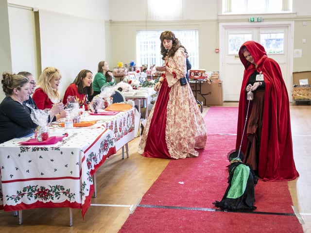 Judges (left) watch on as a woman walks her dog down the catwalk during the Victorian Christmas themed Furbabies Dog Pageant at Collingham Memorial Hall, Leeds.