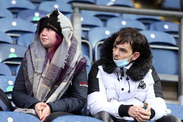 These North End fans try to stay warm and dry before the game at Blackburn