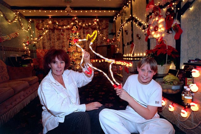 Elaine Idle is pictured with her son Jay inside their front room which is covered with Christmas decorations. She spent more than two weeks putting up over 2,500 Christmas lights inside and outside her New Farnley home.