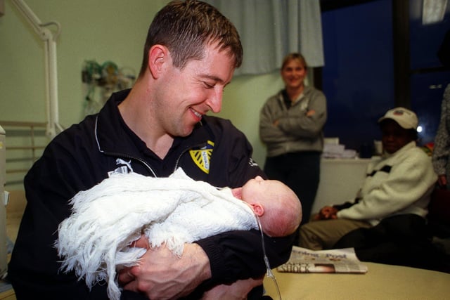 Jake McLaughinis pictured asleep in the arms of the Leeds United goalkeeper Nigel Martyn during the team's visit to the children's ward at St James's Hospital.