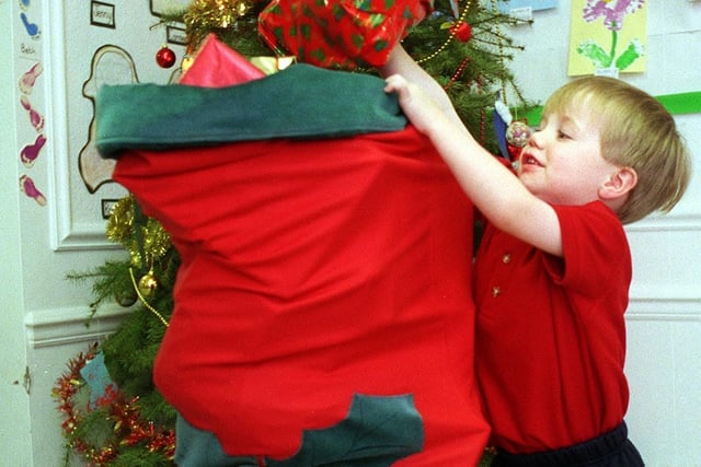 Charles Wilson  puts in the final present in a giant Christmas stocking bound for Martin House Children's Hospice. The presents were donated by staff and parents from the Bright Skies Day Nursery, Rawdon.