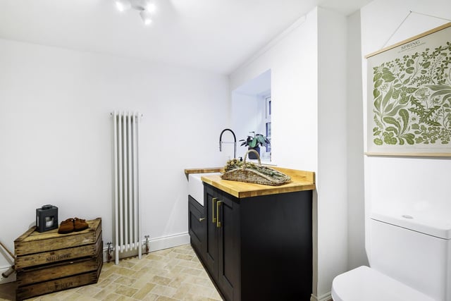 The cloakroom/boot room n the ground floor with shaker style kitchen units, Belfast sink, low flush W.C., vertical radiator, boot storage and bench.