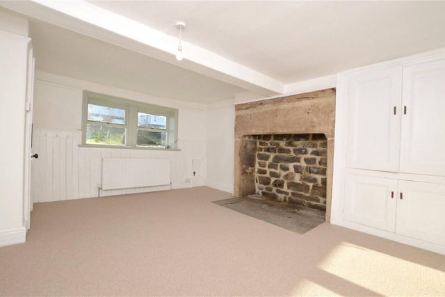 The property has two reception rooms. This one has in-built storage and traditional feature fireplace.