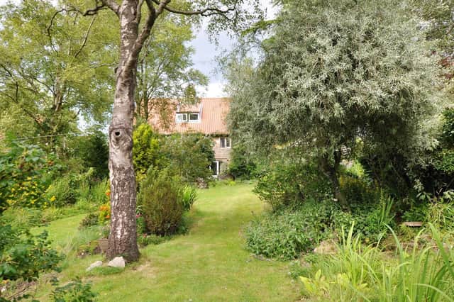 A view of the house form the leafy lawned garden.