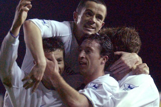 Robbie Fowler celebrates with his teammates after scoring his second goal for Leeds United.