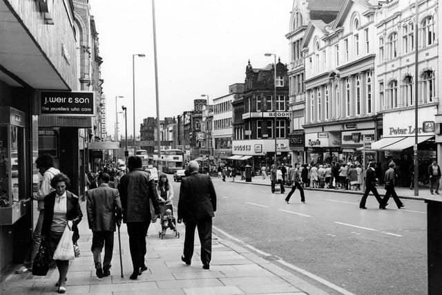 A busy Briggate in April 1979. On the left is J.Weir & Son 'the jeweller's who care' and further down, Debenhams. On the right, Dolcies shoe shop is visible on the corner with Albion Place, then Hornes and Hepworths followed by the Army Stores and Peter Lord's far right.