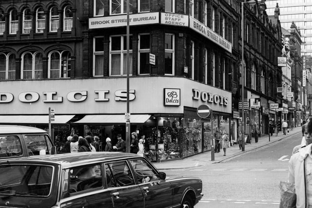 King Edward Street to Briggate and the junction with Albion Place in April 1979. Dolcis shoe shop is on the corner of Briggate and Albion PLace and above, at number 17 Albion Place, is Brook Street Bureau, office staff agency. West Riding House is visible in the background.
