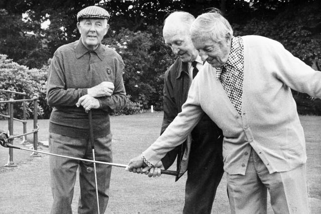 Golf great Henry Cotton (right) gives 80-year-old Joe Gent a few tips on how to improve his game with some tyre exercises on the first tee at Moortown in July 1979. He is watched by the former British Amateur champion Alex Kyle.