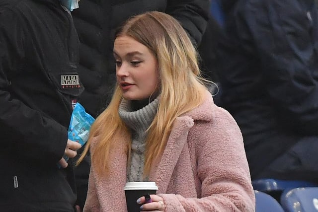 A PNE fans makes her way to her seat holding a warm drink