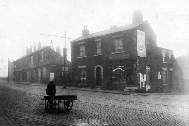 Burley Street in October 1928.  Shop and house, premises of F and H Tomlin, confectioners. 'Bovril' poster on wall. On the left, row of shops, to the right, junction with St. Andrews Street. Broad cobbled road with tramlines.